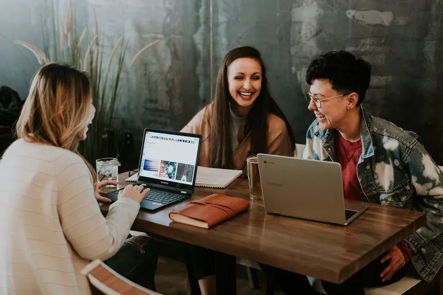 Professionals werken met laptops samen aan een tafel