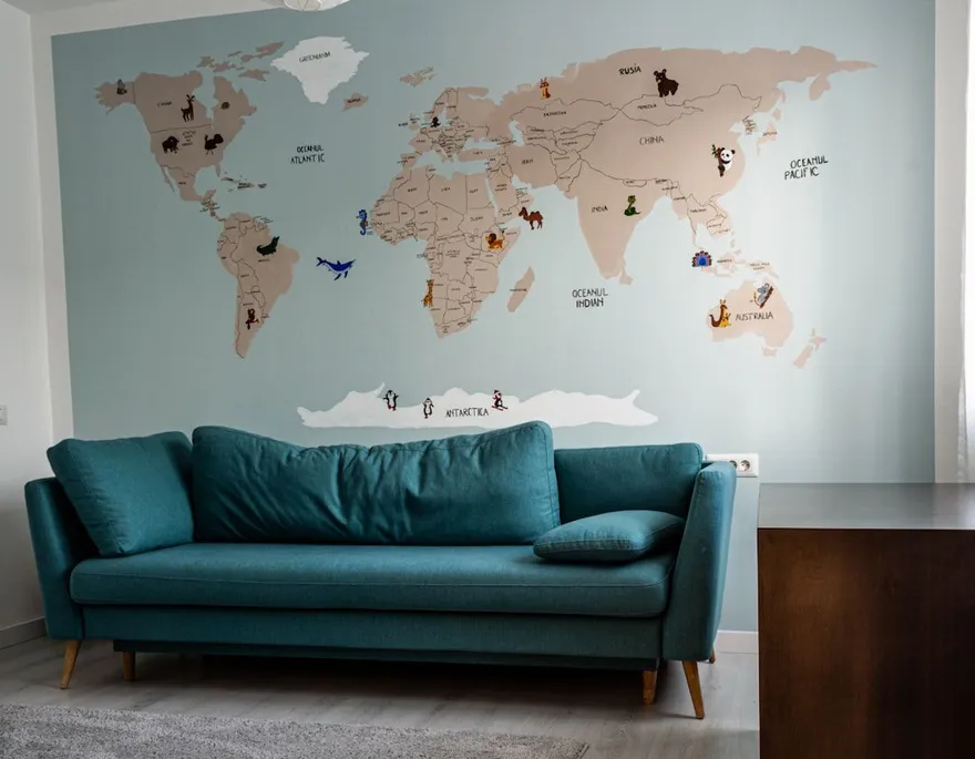 Wereldkaart aan de muur boven een petrolkleurige bank